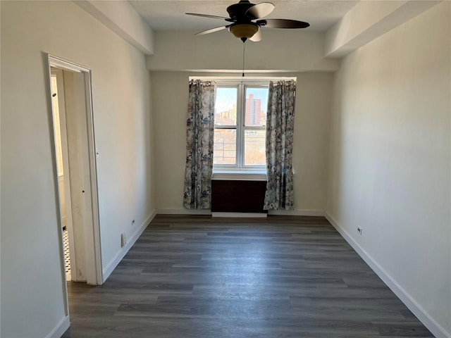 unfurnished room with baseboards, wood finished floors, and ceiling fan
