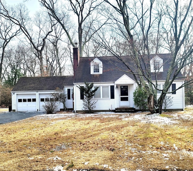 cape cod home featuring a garage and a front yard