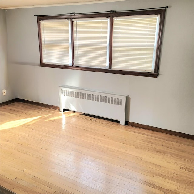 spare room with radiator and light hardwood / wood-style flooring