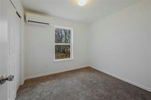 unfurnished bedroom featuring dark colored carpet, a wall unit AC, and a closet