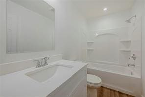 full bathroom with shower / bathing tub combination, vanity, hardwood / wood-style flooring, and toilet