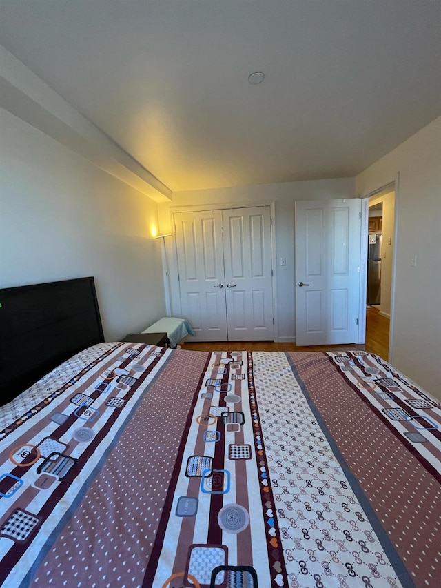 unfurnished bedroom featuring stainless steel refrigerator and a closet