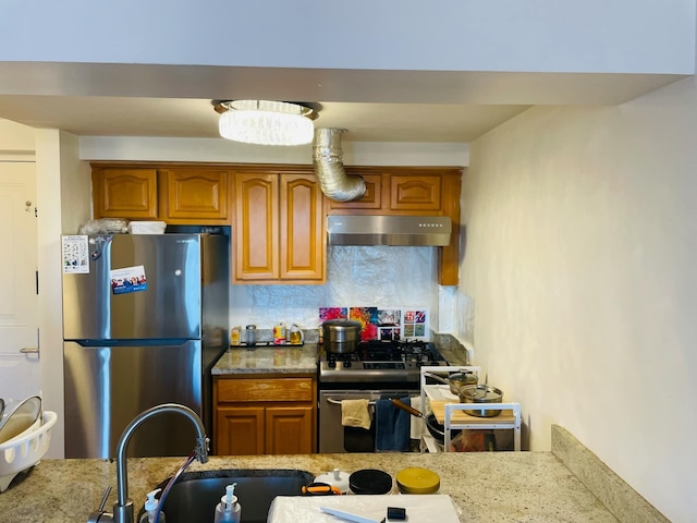 kitchen with tasteful backsplash, sink, stainless steel appliances, and light stone countertops