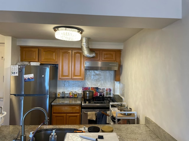 kitchen with tasteful backsplash, dark stone counters, and appliances with stainless steel finishes