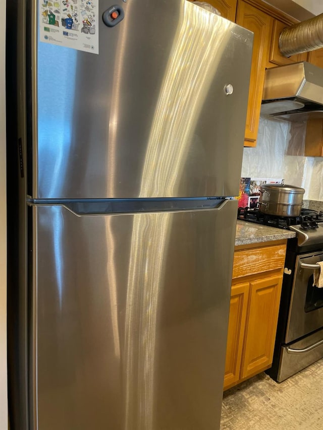 kitchen featuring decorative backsplash, stainless steel appliances, exhaust hood, and stone countertops