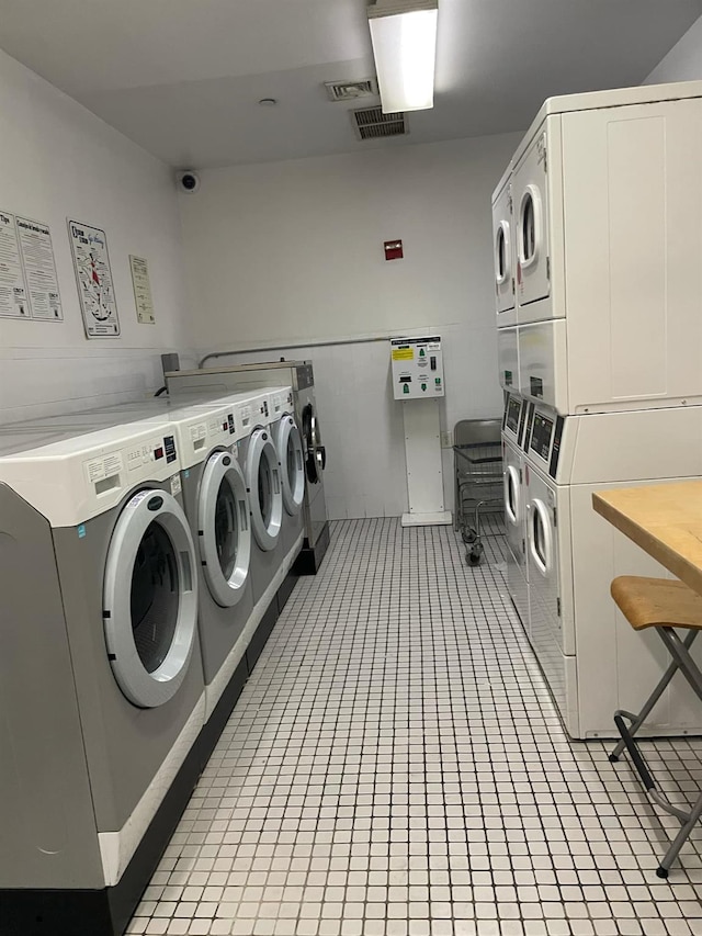 laundry room with light tile patterned floors, washer and dryer, and stacked washing maching and dryer