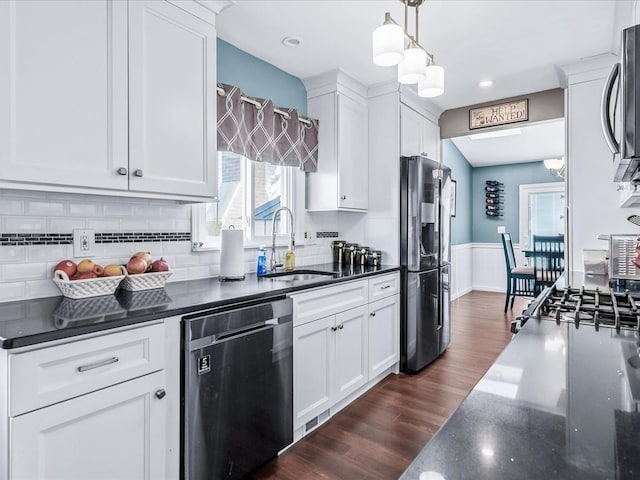 kitchen featuring dark hardwood / wood-style floors, decorative light fixtures, white cabinetry, sink, and stainless steel appliances