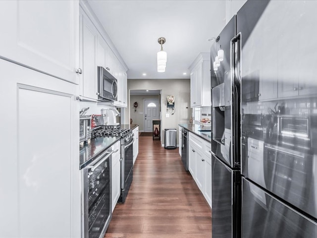 kitchen featuring dark hardwood / wood-style floors, white cabinets, wine cooler, hanging light fixtures, and stainless steel appliances