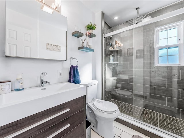 bathroom with vanity, a shower with shower door, tile patterned floors, and toilet