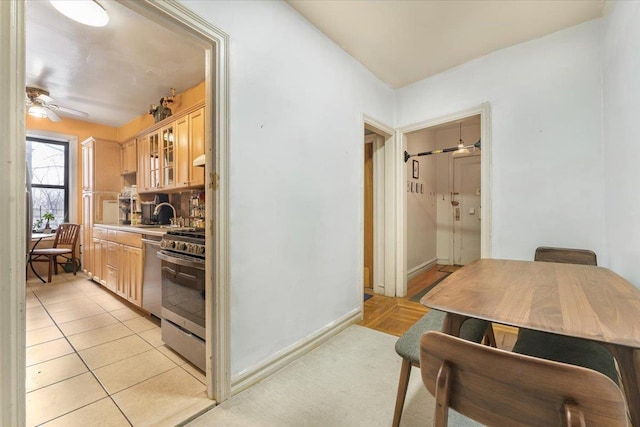 kitchen with ceiling fan, appliances with stainless steel finishes, light tile patterned flooring, decorative backsplash, and light brown cabinets