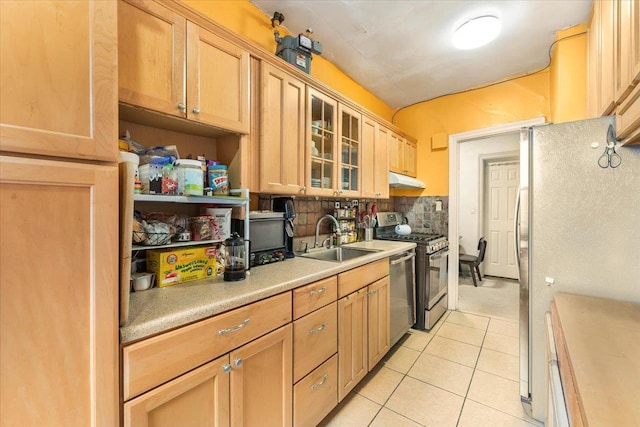 kitchen with sink, light tile patterned floors, stainless steel appliances, light brown cabinetry, and decorative backsplash