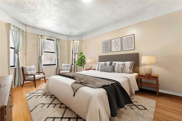 bedroom featuring light hardwood / wood-style flooring and a textured ceiling