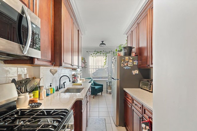 kitchen featuring sink, stainless steel appliances, tasteful backsplash, light stone countertops, and light tile patterned flooring