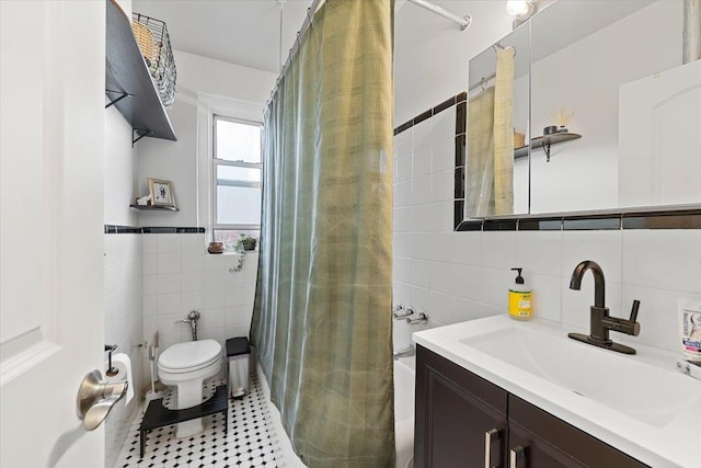 full bathroom with tile walls, tile patterned flooring, vanity, toilet, and shower / bath combo with shower curtain