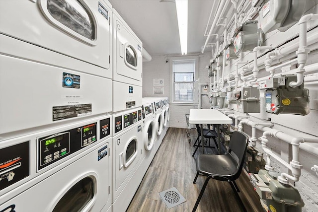 laundry area featuring stacked washer / dryer and hardwood / wood-style floors