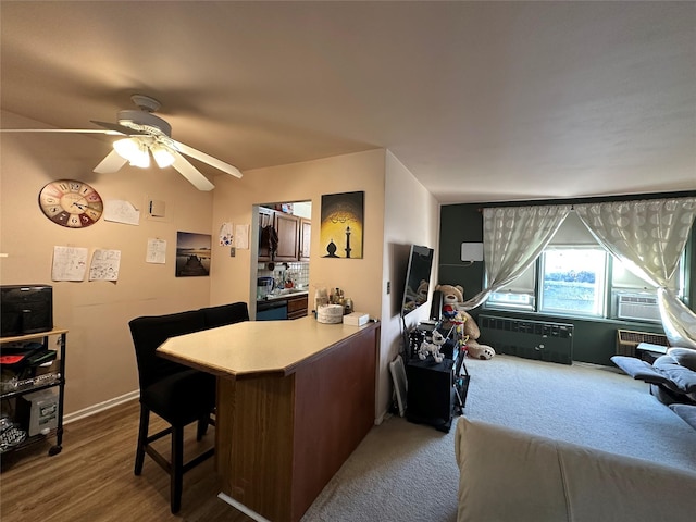 office space featuring hardwood / wood-style flooring, radiator heating unit, and ceiling fan