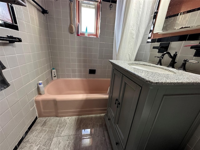 bathroom featuring vanity, tile walls, backsplash, and shower / bath combo with shower curtain