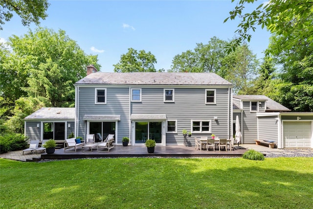 rear view of house featuring a wooden deck, a yard, and a chimney