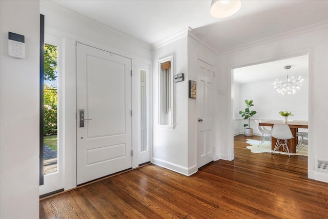 entrance foyer featuring visible vents, crown molding, baseboards, a chandelier, and wood finished floors