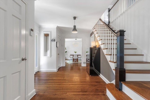 entryway featuring dark wood finished floors, baseboards, and ornamental molding