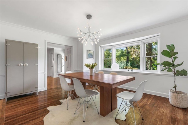 dining space featuring an inviting chandelier, crown molding, wood finished floors, and baseboards