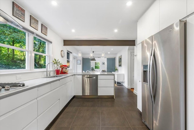 kitchen with modern cabinets, a sink, white cabinetry, stainless steel appliances, and a peninsula