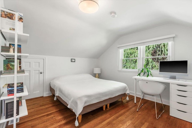 bedroom with baseboards, lofted ceiling, and wood finished floors