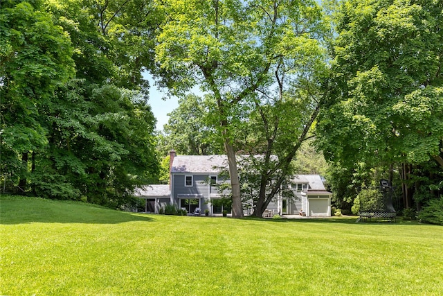 view of front of home with a chimney and a front yard