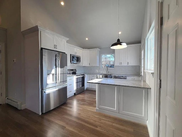 kitchen with vaulted ceiling, decorative light fixtures, white cabinetry, a baseboard radiator, and stainless steel appliances