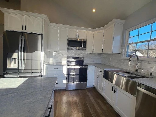 kitchen with sink, appliances with stainless steel finishes, backsplash, dark hardwood / wood-style floors, and white cabinets