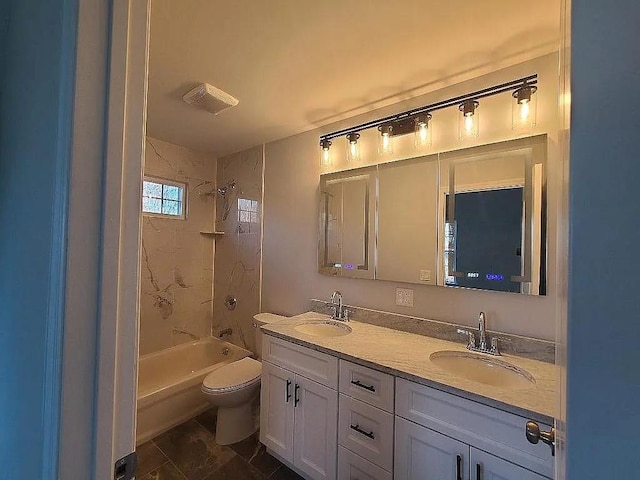 full bathroom with tiled shower / bath, vanity, and toilet