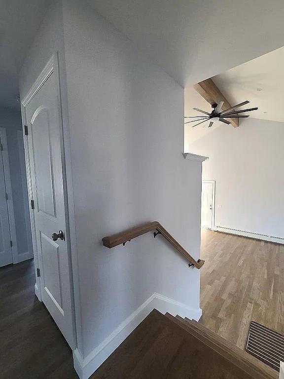 stairway featuring hardwood / wood-style flooring, lofted ceiling, and ceiling fan