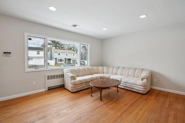 living room featuring radiator and light hardwood / wood-style flooring