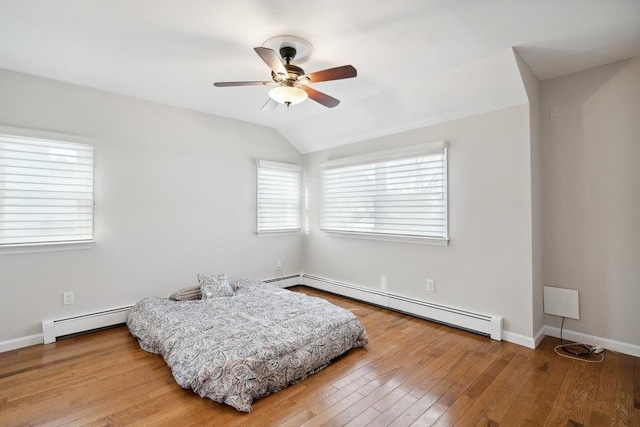 interior space featuring hardwood / wood-style floors, a baseboard radiator, ceiling fan, and vaulted ceiling