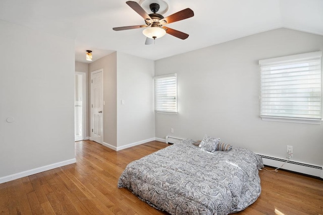 bedroom with baseboard heating, ceiling fan, lofted ceiling, and hardwood / wood-style floors