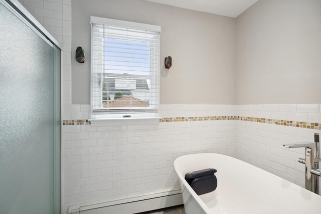 bathroom featuring baseboard heating, plus walk in shower, and tile walls