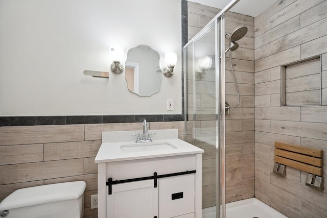 bathroom with vanity, tile walls, an enclosed shower, and toilet