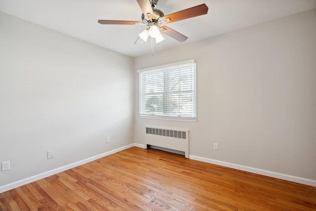 unfurnished room featuring ceiling fan, radiator, and light hardwood / wood-style floors