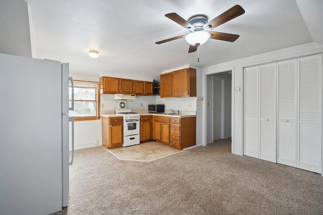 kitchen with ceiling fan, sink, light colored carpet, and white appliances