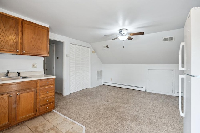 kitchen featuring sink, ceiling fan, a baseboard heating unit, light carpet, and vaulted ceiling