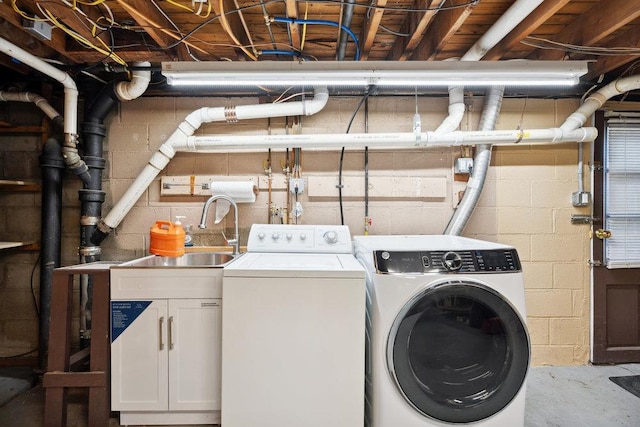 laundry room with sink, washer and clothes dryer, and cabinets