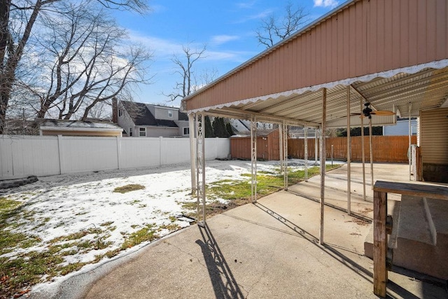 snow covered patio with a storage unit