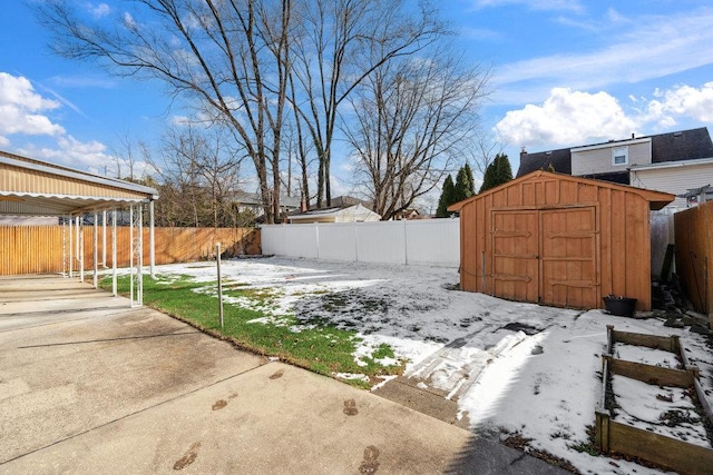 snowy yard with a storage shed and a patio