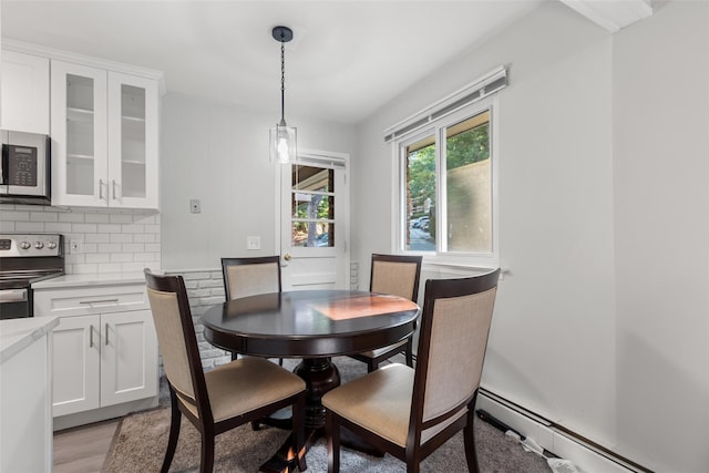 dining space with baseboard heating and light hardwood / wood-style flooring