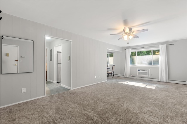 carpeted empty room featuring an AC wall unit, ceiling fan, and baseboard heating