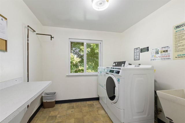 clothes washing area featuring sink and washer and dryer