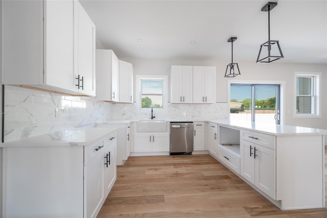 kitchen featuring sink, decorative light fixtures, light wood-type flooring, dishwasher, and white cabinets