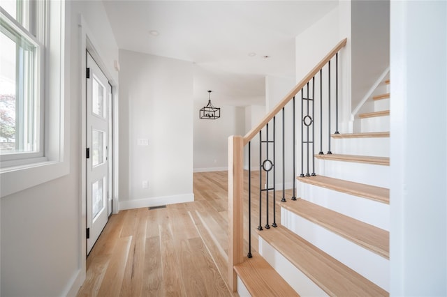 entrance foyer featuring light hardwood / wood-style flooring and a notable chandelier