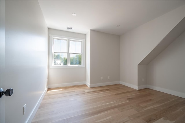 additional living space with light hardwood / wood-style floors