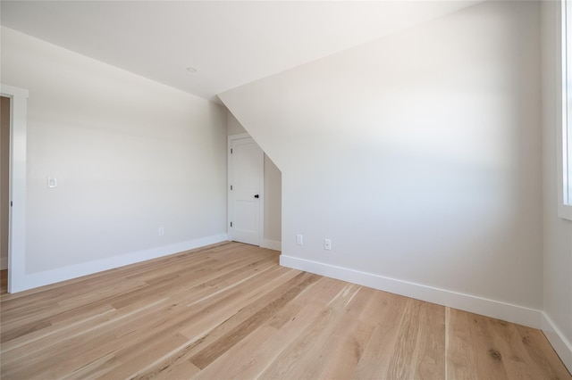 additional living space featuring lofted ceiling and light hardwood / wood-style floors